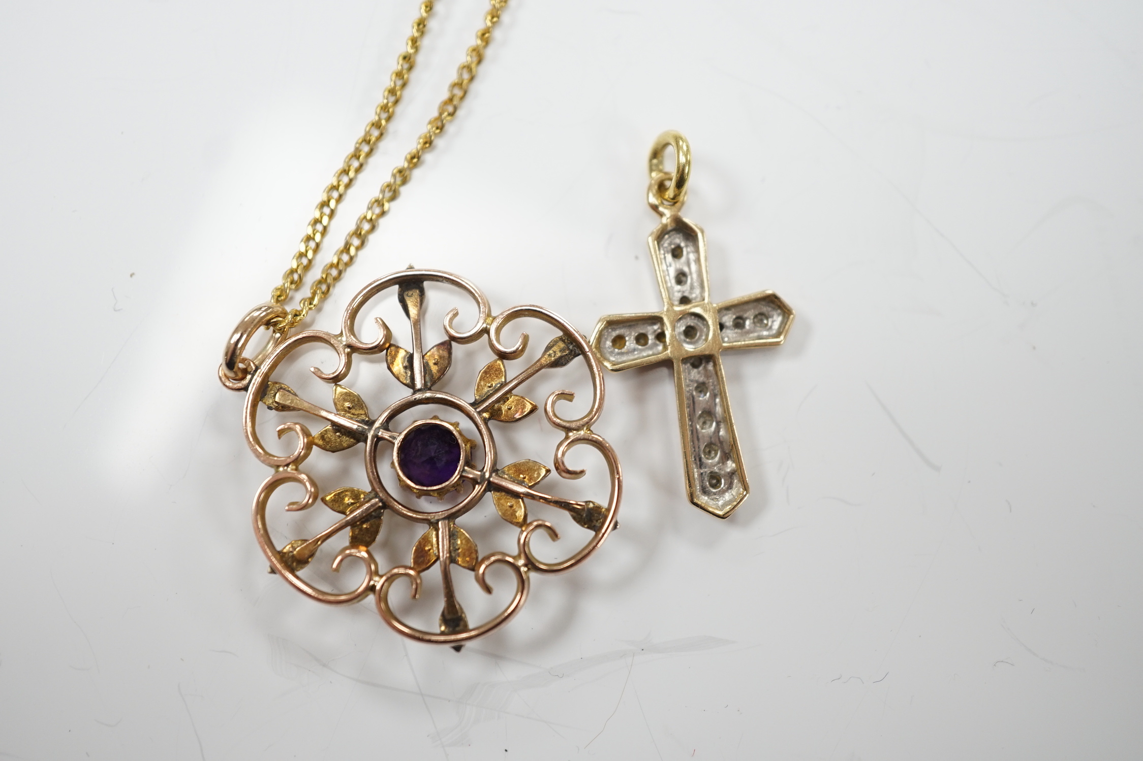 An early 20th century yellow metal, amethyst and seed pearl set pendant, 32mm, on a gilt metal chain, together with a modern yellow metal and diamond set cross pendant.
